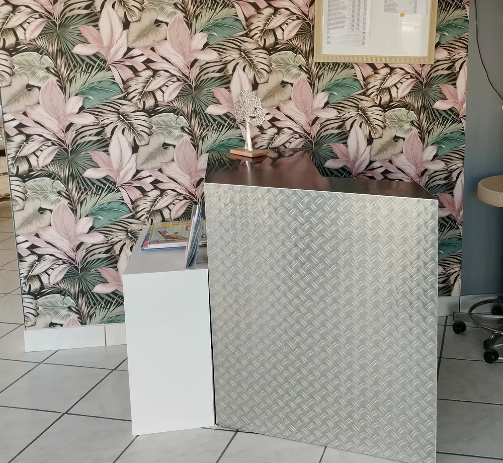 Le papier peint du salon, grandes feuilles roses et vertes sur fond sombre